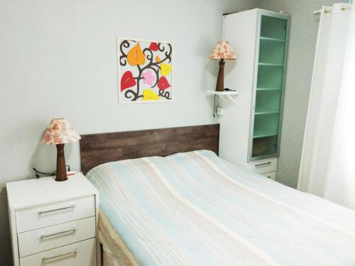 a bedroom with a bed and two lamps on dressers at Espaço aconchegante Blumenau in Blumenau