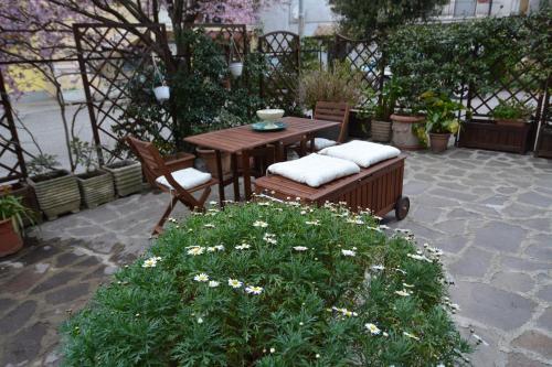 a patio with a table and two chairs and a table and flowers at La casetta degli agricoltori in Vetralla