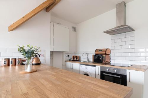 cocina con paredes blancas y encimera de madera en Yarm Lane Apartments - Stockton Town Centre en Stockton-on-Tees
