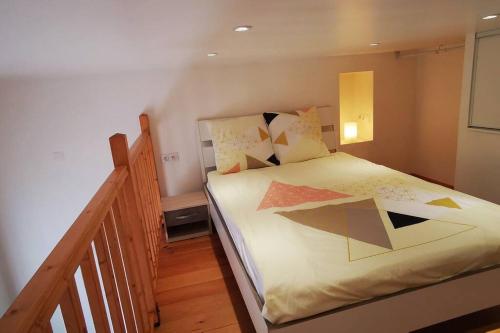 - une petite chambre avec un lit et des oreillers colorés dans l'établissement Studio privé/ centre-ville/ proche du parc Walibi, à Les Avenières