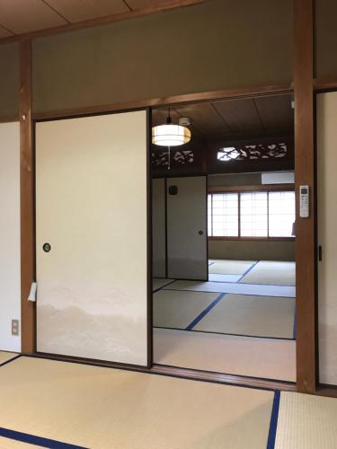 een lege kamer met een glazen schuifdeur bij Kyoto Guesthouse Oyado Kei in Kyoto