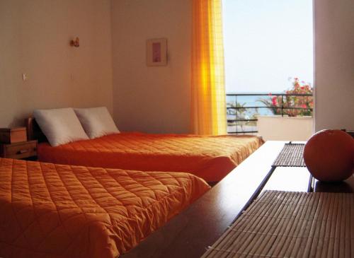 three beds in a room with a view of the ocean at Sirius in Kanali