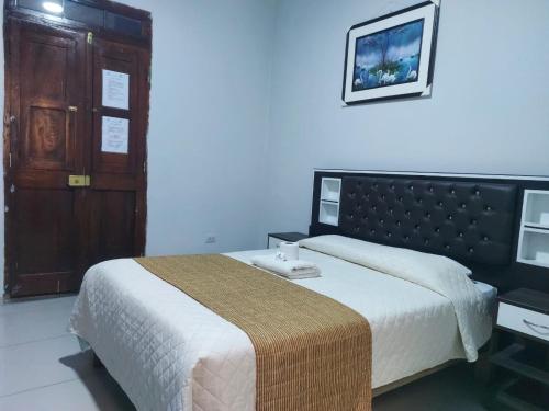 a bedroom with a large bed and a wooden door at HOSTAL espinoza in Arequipa