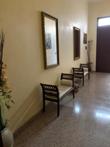 a waiting room with two chairs and a mirror at B & B Il Giardino in Noto