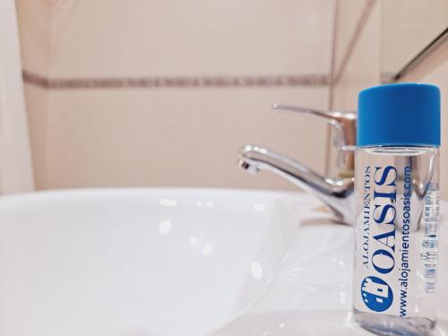 - Botella de pasta de dientes en el lavabo del baño en Apartamentos Turísticos Taymar, en Chiclana de la Frontera