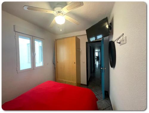 een slaapkamer met een rood bed en een plafondventilator bij Magnifique Appartement • vue sur mer • Santa Pola in Santa Pola