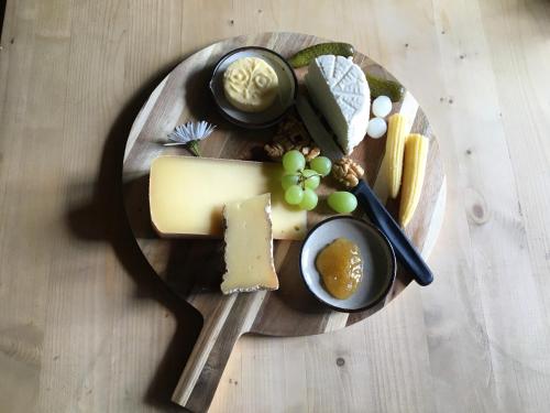 um prato de queijo e outros alimentos sobre uma mesa em Alp Es-Cha Dadour em Madulain