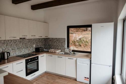 a kitchen with white cabinets and a sink at Cabana Nicorici in Cluj-Napoca