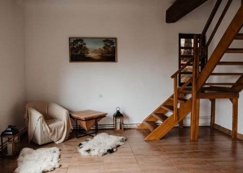 a living room with a chair and a staircase at Cabana Nicorici in Cluj-Napoca