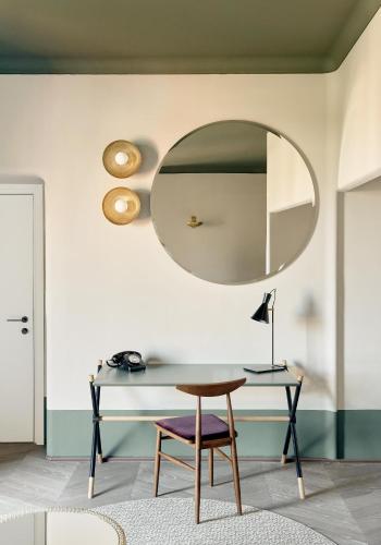 a table and a chair in a room with a mirror at Palazzo Velabro, a Member of Design Hotels in Rome