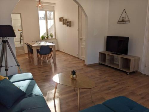 un salon avec un canapé bleu et une table dans l'établissement l'Opale Break, à Calais