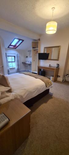 a large bedroom with a large bed and a desk at Glen Garth Guest House in Chester