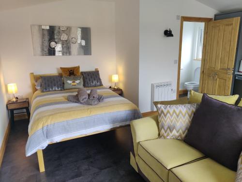 a bedroom with a bed and a couch at Bumble Bee Cabin in Bootle