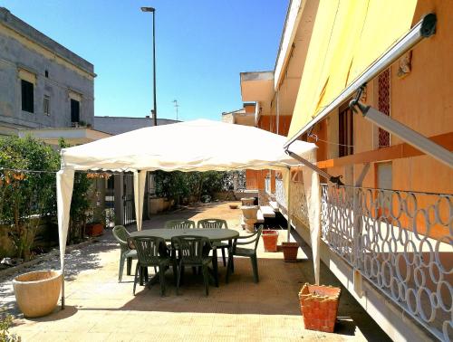 een tafel en stoelen onder een parasol op een balkon bij Villetta Hydro 3 in Bagnolo del Salento