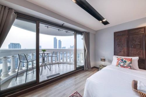 um quarto com uma cama e uma varanda com uma mesa em Central Bangkok, 5 stars river view & characteristic decor em Bangkok
