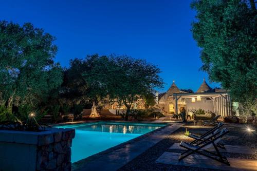 a swimming pool in a backyard at night at Trulli cicale e olive in Ceglie Messapica