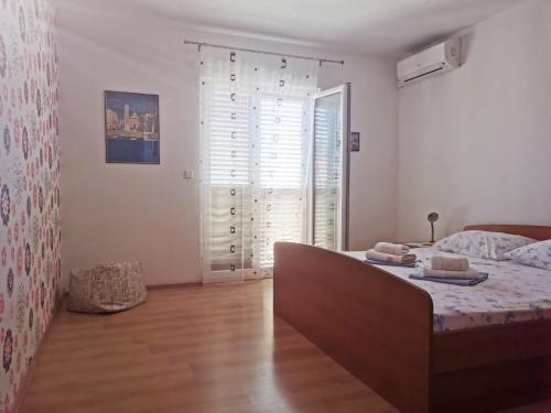 a bedroom with a bed and a large window at Babo Apartments in Hvar