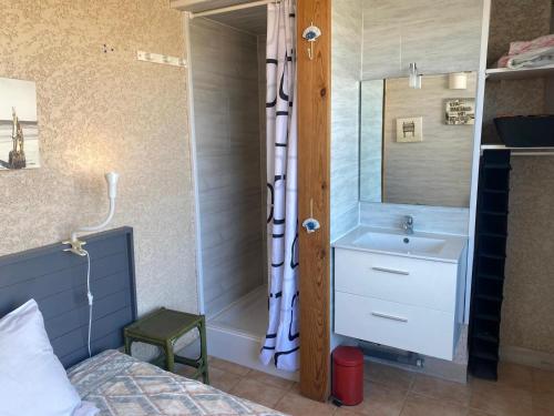 sypialnia z umywalką, łóżkiem i lustrem w obiekcie SAMARIA VILLAGE Magnifique appartement 8 personnes Rochelongue Cap d'Agde w Cap d'Agde