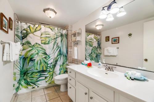 a bathroom with a sink and a toilet and a shower curtain at Kona Makai 3102 in Kailua-Kona