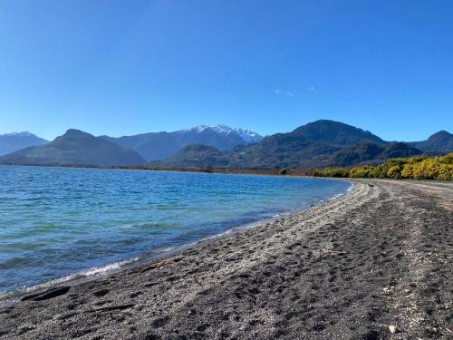 vistas a una playa con montañas en el fondo en Cabañas Piukewen, en Riñinahue