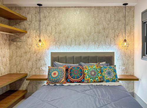 a bedroom with a bed with pillows and two lights at Apto incrivel a 50m do metro Butanta em Sao Paulo in Sao Paulo