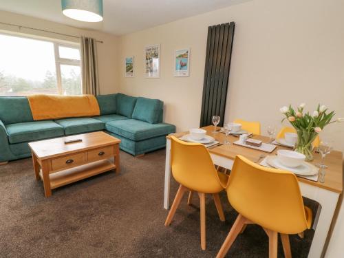 a living room with a table and a couch at Wren's Nest Manorcombe in Callington
