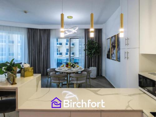ドバイにあるBirchfort - Newly Renovated Huge 2 bedroom apartmentのキッチン、リビングルーム(テーブル、椅子付)