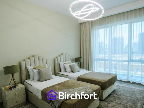 a bedroom with two beds and a large window at Birchfort - Newly Renovated Huge 2 bedroom apartment in Dubai