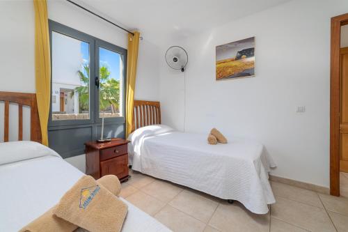 Un dormitorio con dos camas y una ventana en Casa LAGO, en Playa Blanca