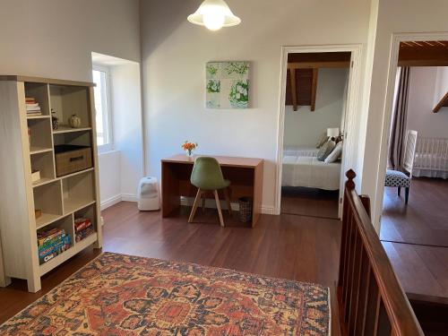 a living room with a desk and a bedroom at Maria's Haven in Santo António