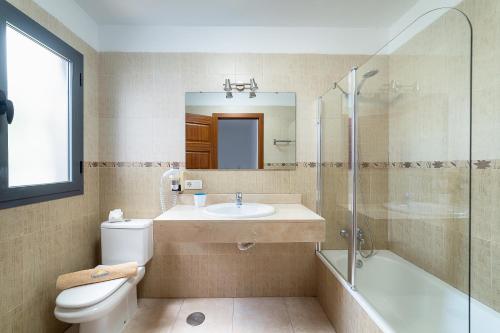 y baño con lavabo, aseo y ducha. en Casa LAGO en Playa Blanca