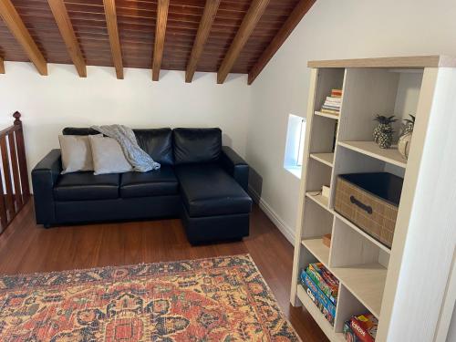 a living room with a couch and a book shelf at Maria's Haven in Santo António