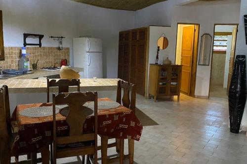 eine Küche mit einem Tisch und Stühlen sowie eine Küche mit einem Kühlschrank in der Unterkunft Case beach in Ngalou Sessène
