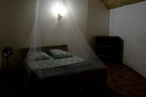 Schlafzimmer mit einem Bett mit Moskitonetz in der Unterkunft Case beach in Ngalou Sessène