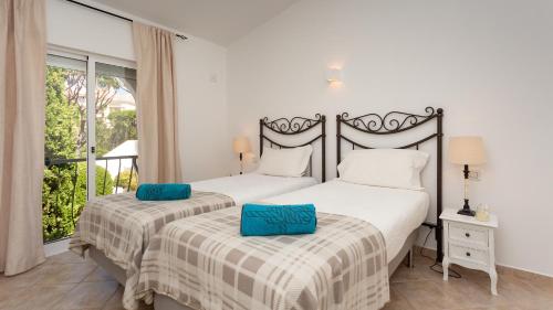 two twin beds in a bedroom with a window at Casa Julia - Dunas Douradas in Faro