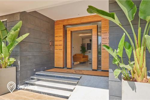 um corredor com escadas e plantas numa casa em Stayhere Rabat - Hay Riad - Sophisticated Residence em Rabat