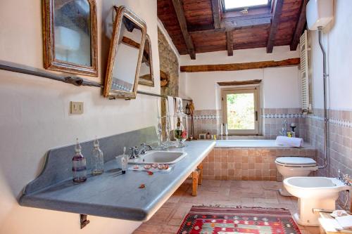 a bathroom with a sink and a toilet and a tub at Ca' Lo Spicchio in Monte San Pietro