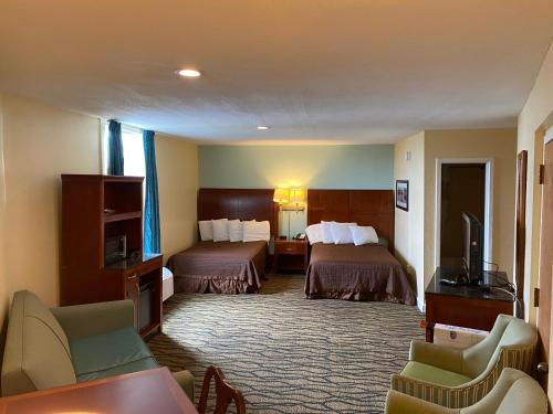 pokój hotelowy z dwoma łóżkami i telewizorem w obiekcie Outer Banks Inn w mieście Kill Devil Hills