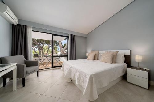 a bedroom with a bed and a desk and a window at Apartment Victoria - Quinta do Lago in Quinta do Lago