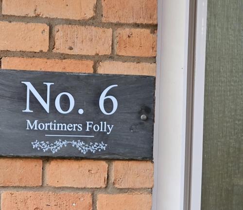 ein kein Schild an einer Ziegelmauer in der Unterkunft Ground floor well appointed cosy flat in Ludlow in Ludlow