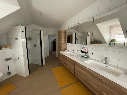 a large bathroom with two sinks and a shower at Ferienzimmer Claudia in Surwold