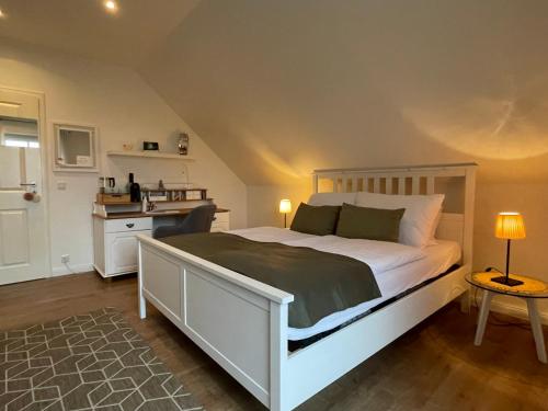 - une chambre avec un grand lit blanc et une table dans l'établissement Ferienzimmer Claudia, à Surwold