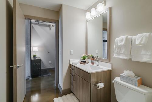 ein Badezimmer mit einem Waschbecken, einem WC und einem Spiegel in der Unterkunft Sable 56 - One Bedroom in Minneapolis