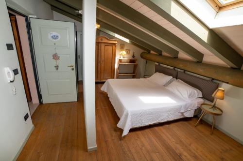 a bedroom with a white bed in a attic at Villa Monica in Brentonico