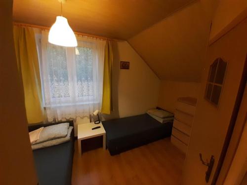 Habitación pequeña con cama y ventana en NSSM Tanie Spanie, en Święta Katarzyna