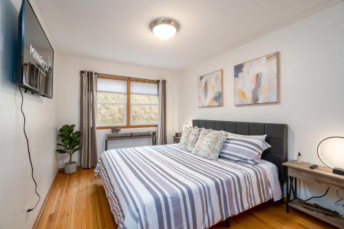 ein Schlafzimmer mit einem Bett und einem TV in der Unterkunft Linden Hills Retreat in Minneapolis