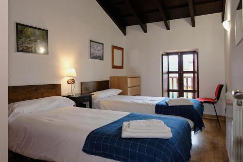 希洪的住宿－Casa de pueblo adosada, en la zona rural de Gijón.，酒店客房,设有两张床和一张红色椅子