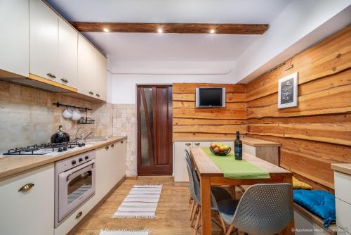 een keuken met houten wanden en een tafel met een fles wijn bij Apartament Nordic in Gura Humorului