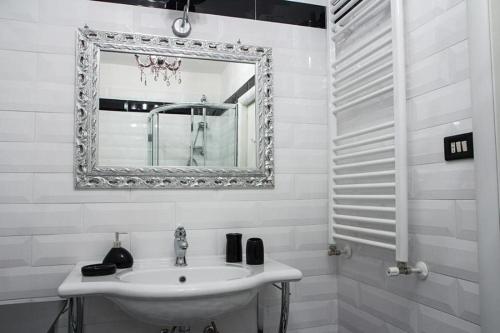 a white bathroom with a sink and a mirror at Portobello Appartamento 3 camere 3 bagni in Taranto