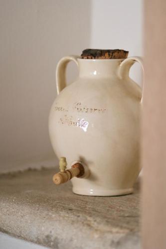 a white vase sitting on a counter with a bottle at LA FERME DE LA HUPPE in Gordes